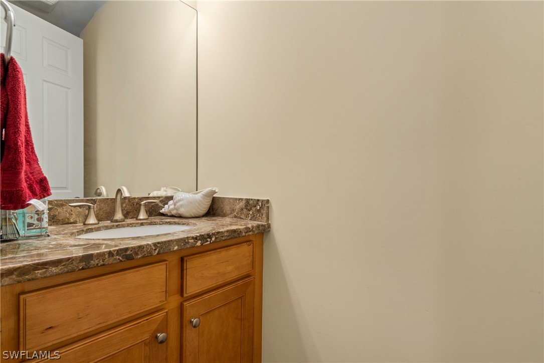 1387 Santiago Circle, Unit 802 Naples, FL 34113 - Photo 22 of 29 a bathroom with a granite countertop sink and a mirror