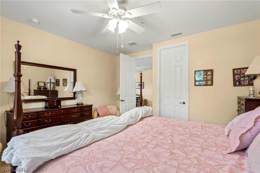 1387 Santiago Circle, Unit 802 Naples, FL 34113 - Photo 29 of 29 a bedroom with a large bed and a chandelier