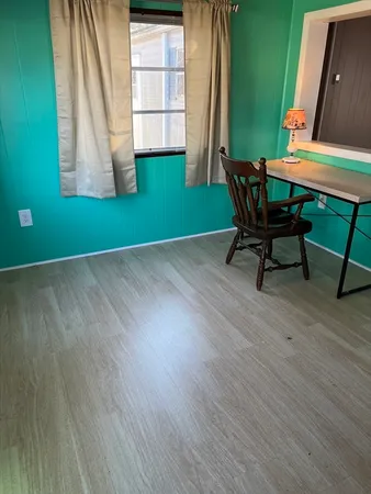 a view of a room with a window and wooden floor