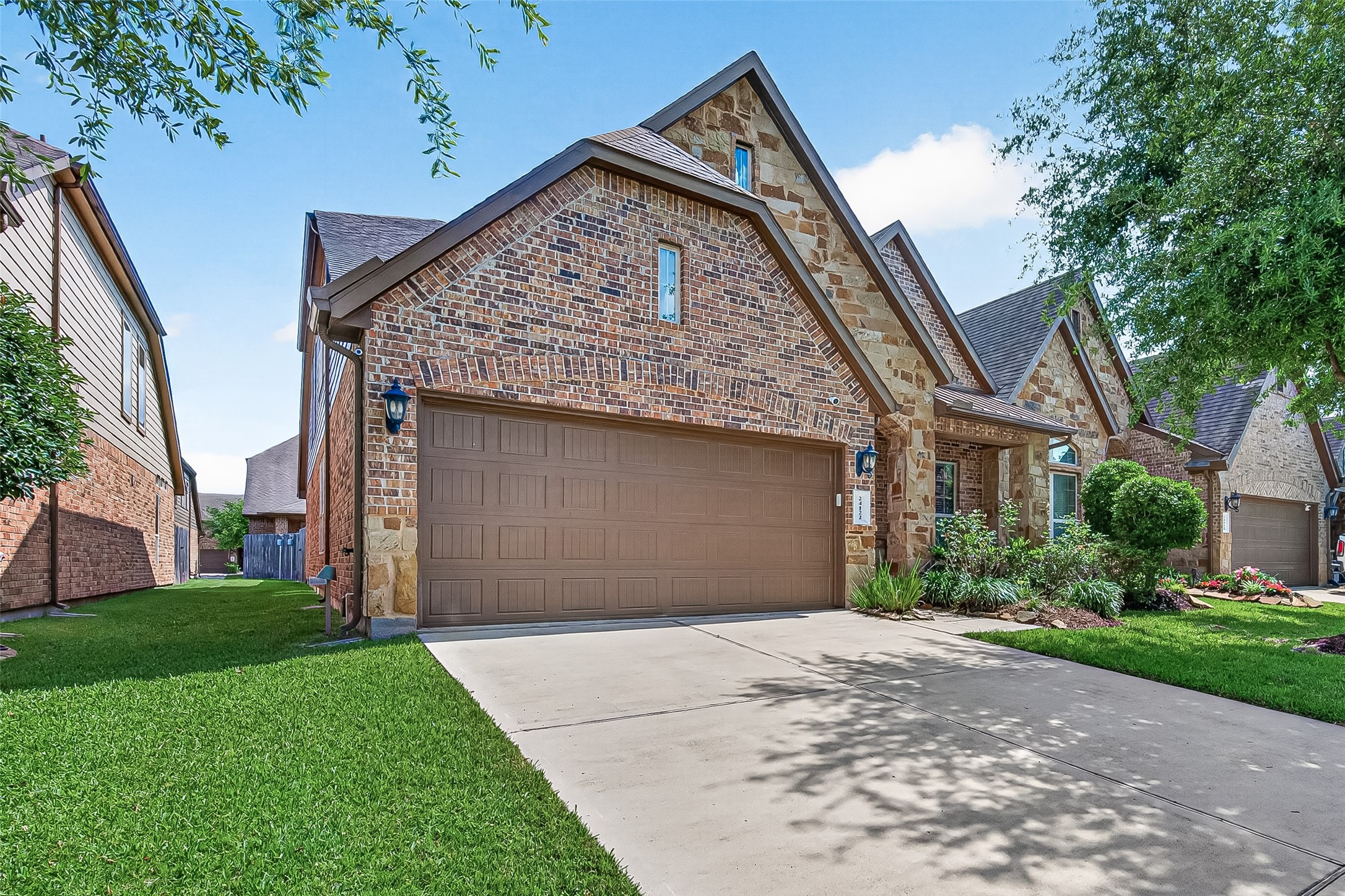 24122 Valencia Ridge Lane Katy, TX 77494 - Photo 3 of 46 Stunning curb appeal with a timeless brick-and-stone facade, manicured lawn maintained by the HOA, and convenient access to community amenities.