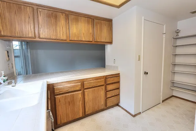 a front view of house with yard and trees all around