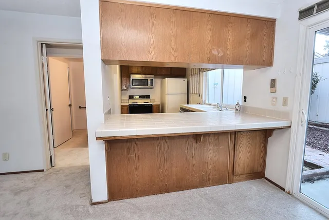 a front view of a house with a yard and potted plants