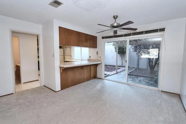 an empty room with a ceiling fan and a window