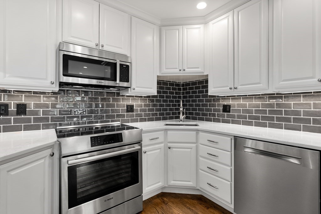 75 Montgomery Street, Unit 4 Boston, MA 02116 - Photo 12 of 14 a kitchen with white cabinets stainless steel appliances and sink