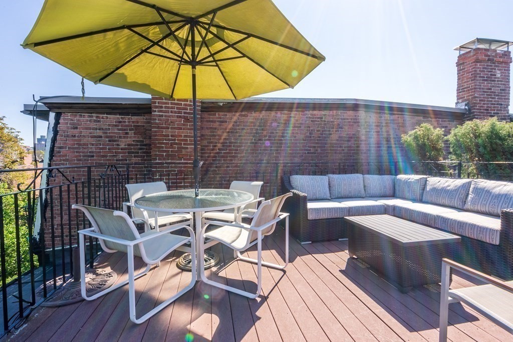 75 Montgomery Street, Unit 4 Boston, MA 02116 - Photo 4 of 14 a patio with patio a table and chairs under an umbrella