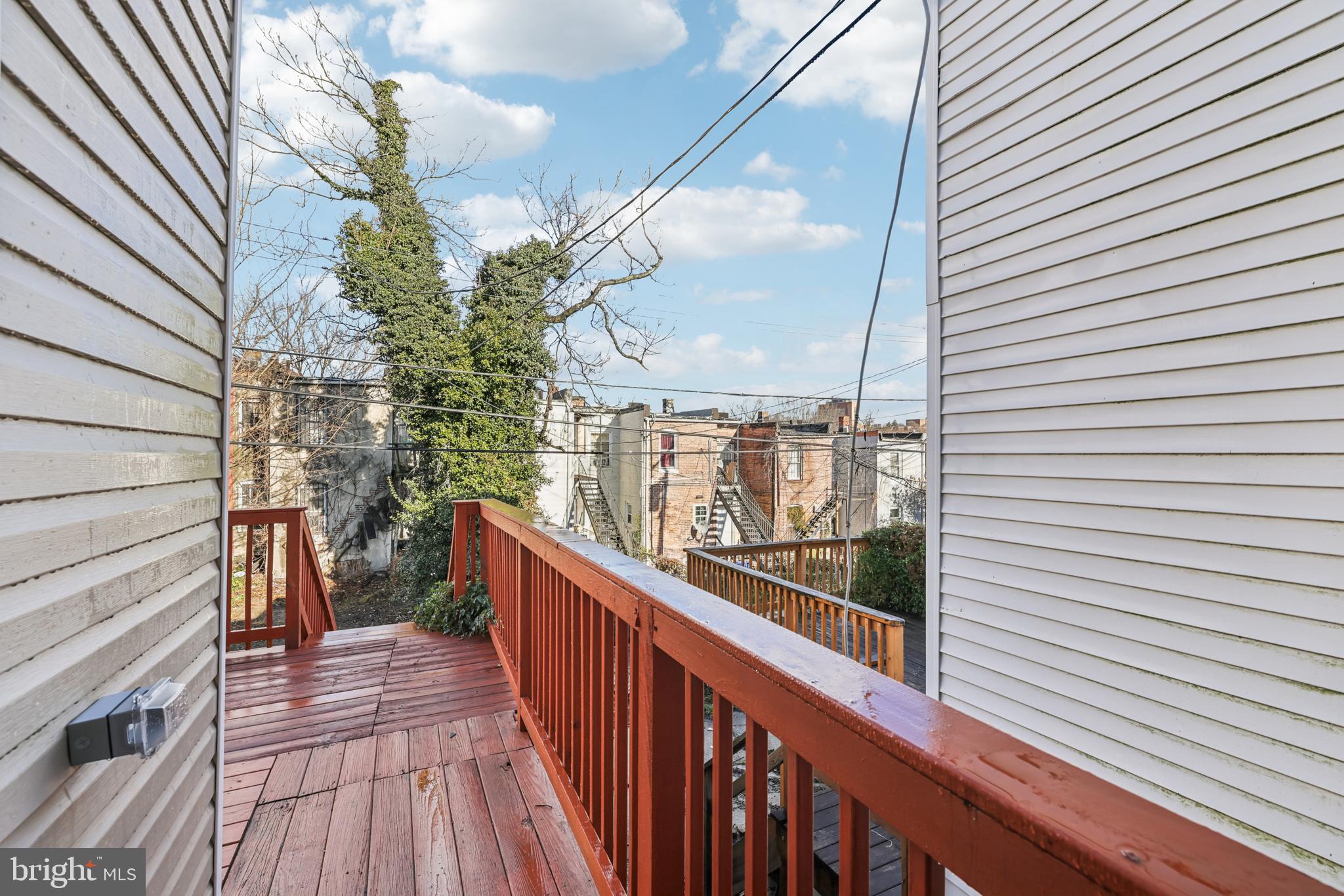 2820 Brighton Street Baltimore, MD 21216 - Photo 33 of 38 a view of a balcony with wooden floor and stairs