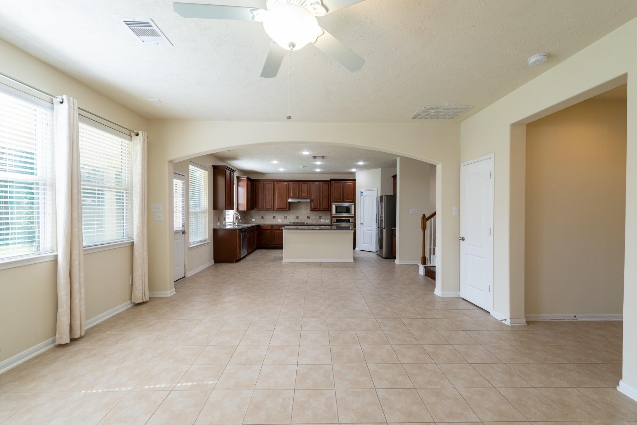 6402 Addlestone Ridge Lane Katy, TX 77494 - Photo 8 of 25 Spacious open-concept family room seamlessly connected to the kitchen and breakfast area, creating the perfect space for entertaining, relaxing, or everyday living. Large windows bring in abundant natural light, while the tile flooring provides both durability and easy maintenance.