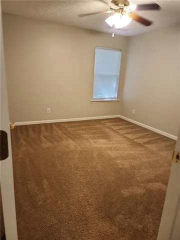 a view of an empty room with a chandelier fan