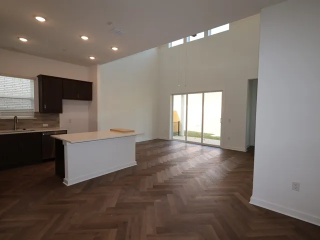 a living room with kitchen island furniture and a flat screen tv