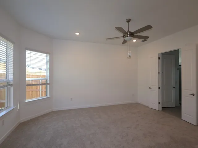 an empty room with a window and a fan