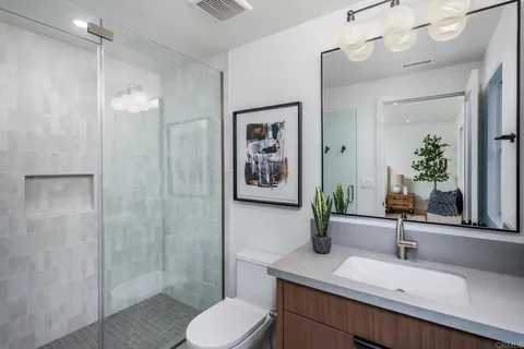 a bathroom with a sink a toilet and shower