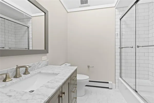 a bathroom with a granite countertop sink toilet and shower
