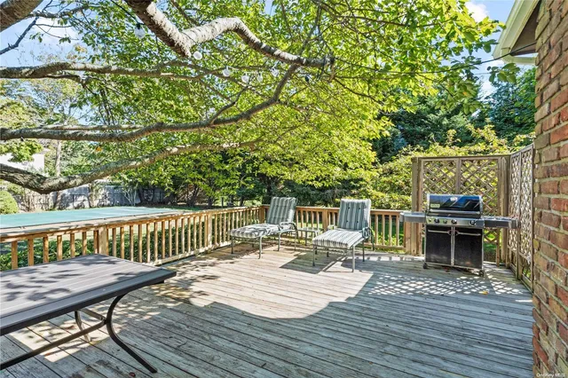 a balcony with wooden floor table and chairs