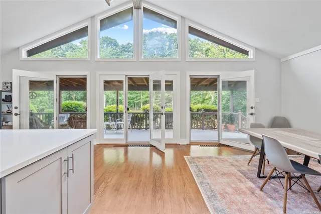 a dining room with wooden floor and glass door