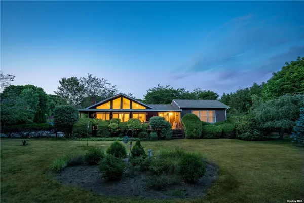 a front view of a house with a yard and green space
