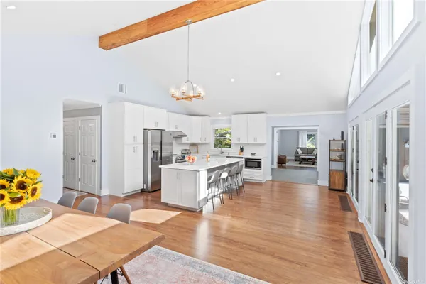 a living room with furniture kitchen view and a wooden floor