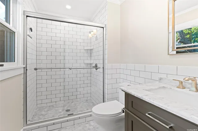 a bathroom with a granite countertop toilet a sink a shower and a mirror