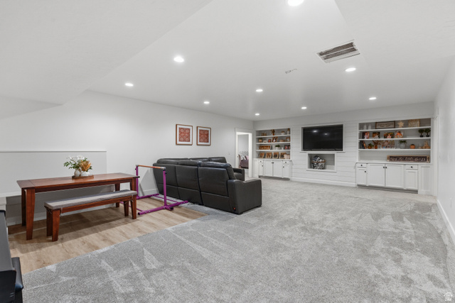 2013 South 100 West Perry, UT 84302 - Photo 31 of 49 Spacious multi-zone interior featuring recessed lighting, a built-in entertainment center with open shelving and lower cabinetry, wood-finish flooring, and soft grey carpeting
