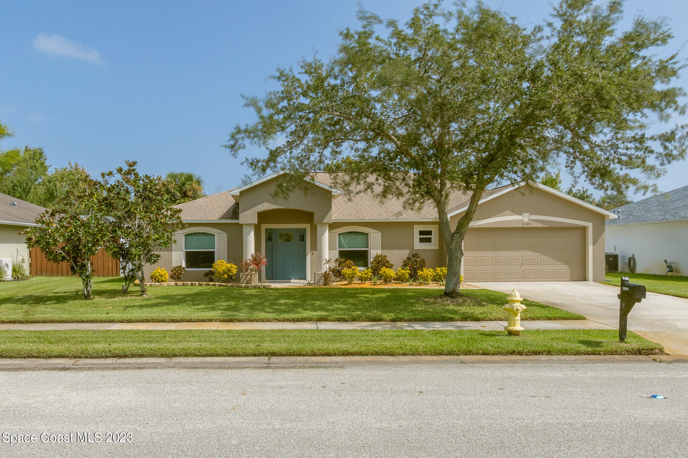 a front view of a house with a garden and trees