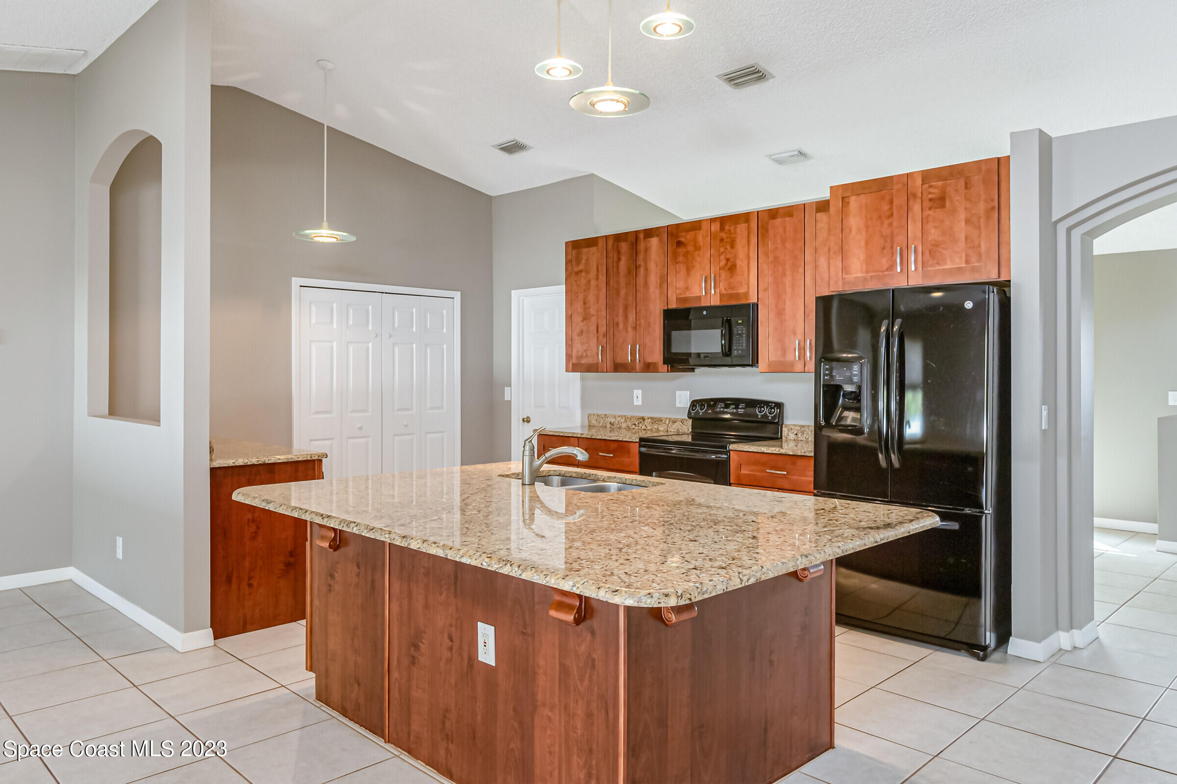4181 Long Leaf Drive Melbourne, FL 32940 - Photo 7 of 37 a kitchen with granite countertop a refrigerator and a stove top oven