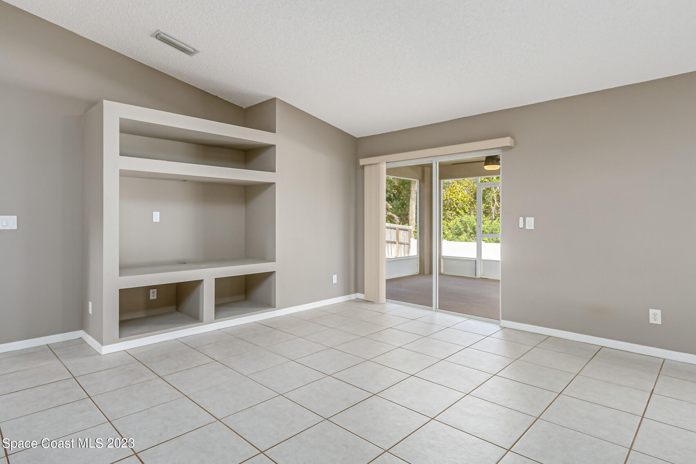 4181 Long Leaf Drive Melbourne, FL 32940 - Photo 9 of 37 a view of an empty room with a fireplace and a window