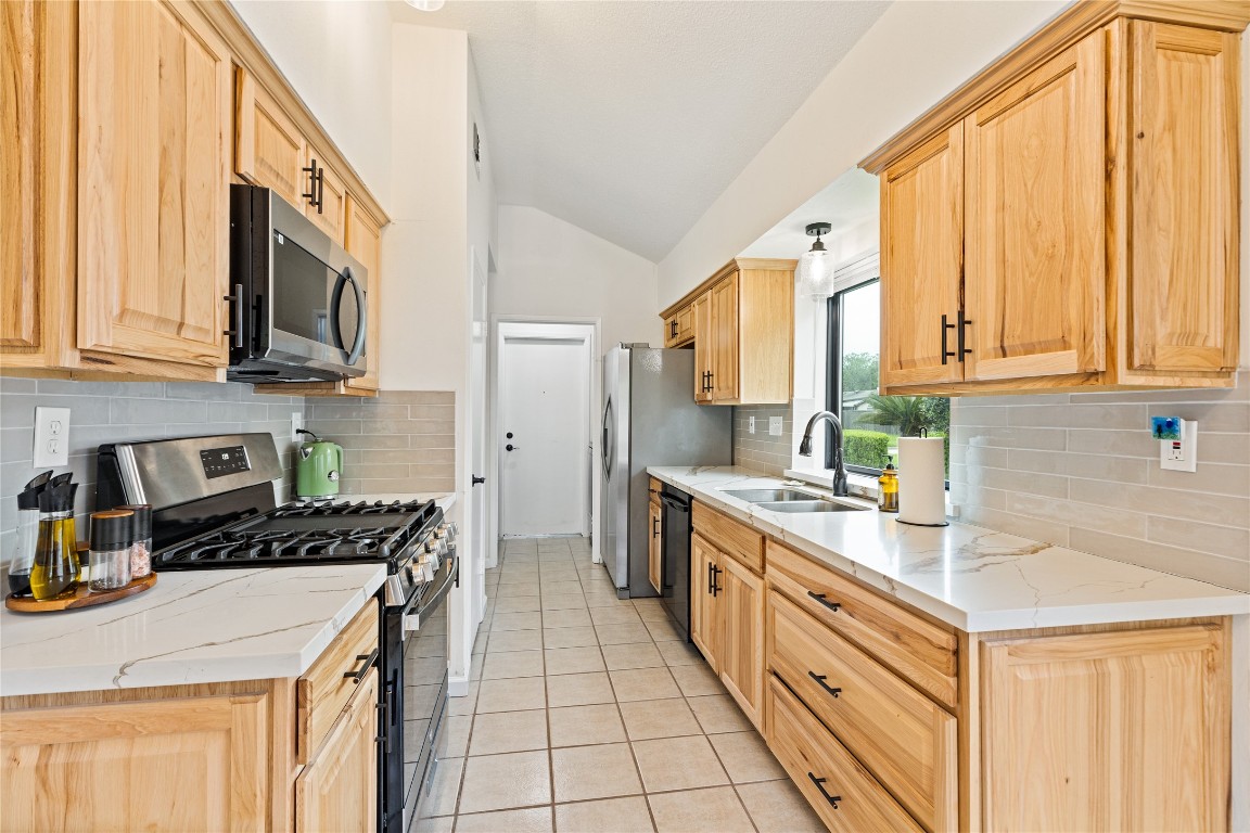 9719 Orangevale Drive Spring, TX 77379 - Photo 9 of 32 Updated kitchen with attractive quartz counters and tile backsplash.