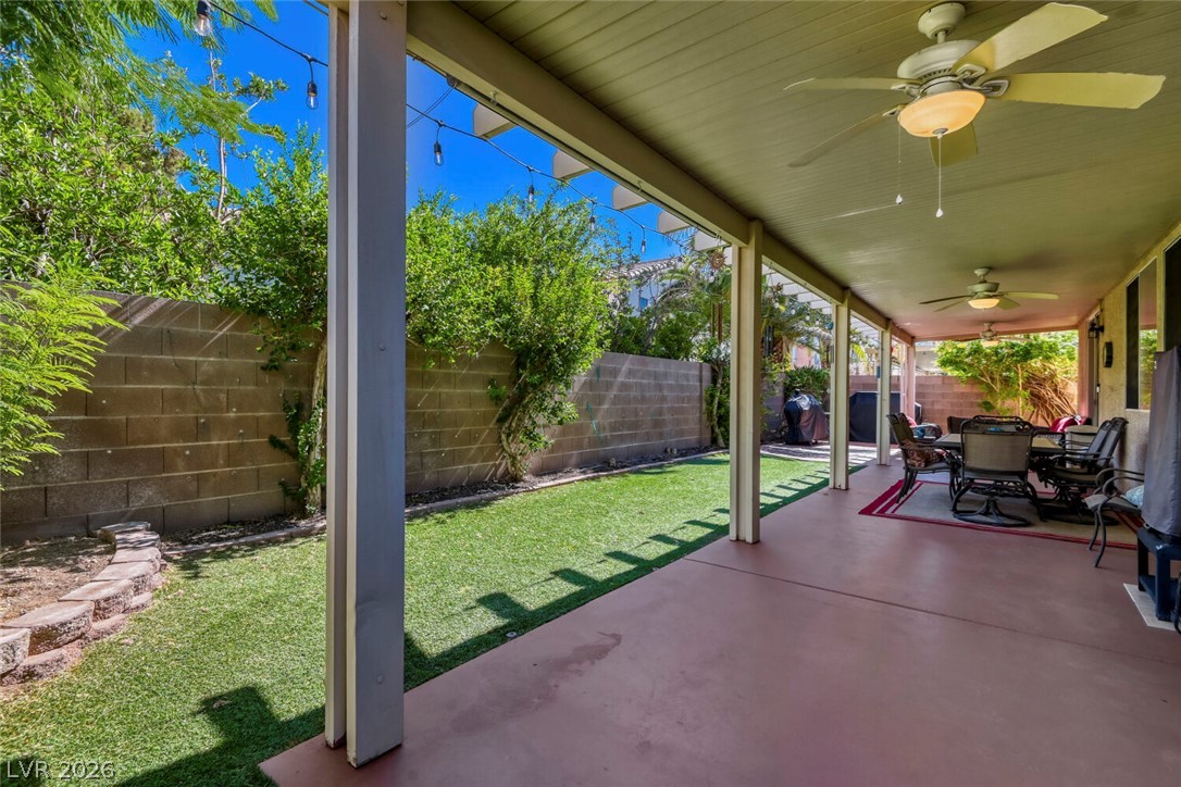 2356 Tilden Way Henderson, NV 89074 - Photo 28 of 30 An inviting covered patio offers ample space for outdoor dining and relaxation with ceiling fans and string lighting.