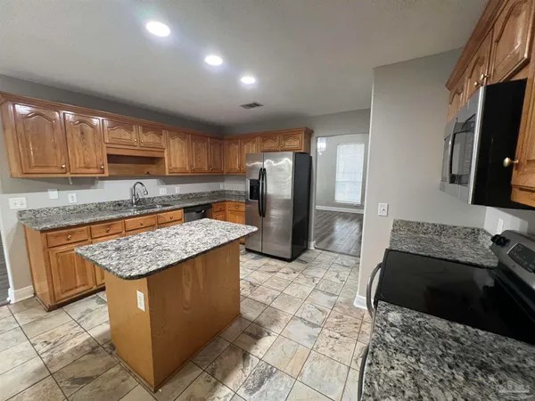 a kitchen with stainless steel appliances granite countertop a sink stove and refrigerator