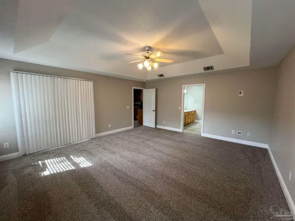 en empty room with windows and fan