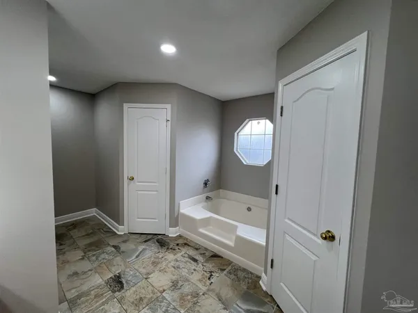 a bathroom with a tub and a mirror