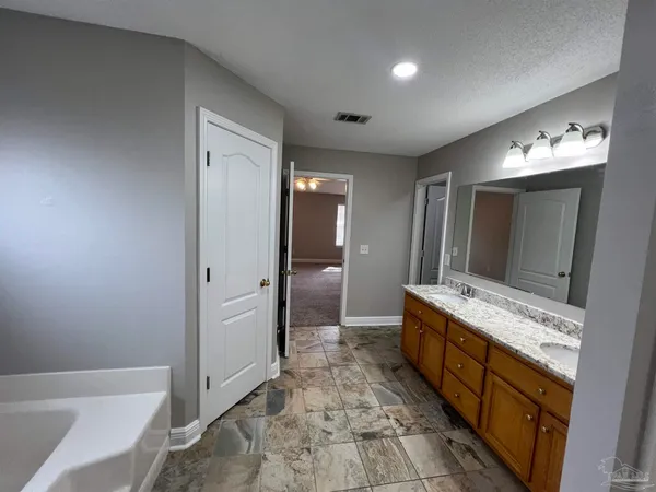 a spacious bathroom with a mirror and a sink