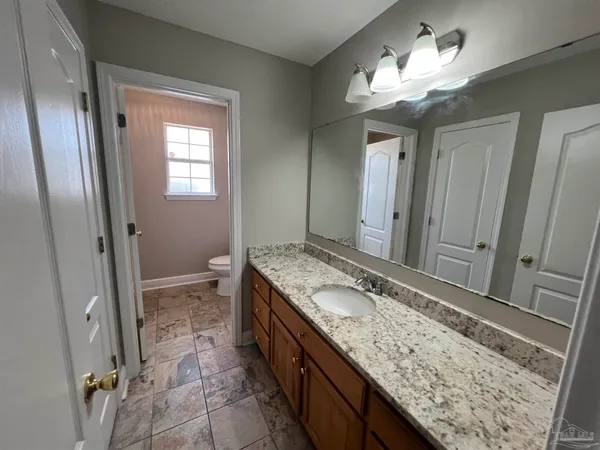 a bathroom with a granite countertop sink a mirror and a shower