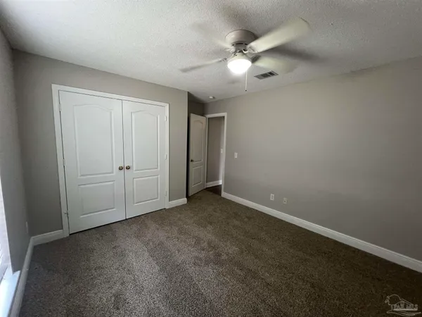 an empty room with a chandelier fan