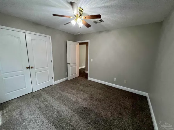 an empty room with a ceiling fan and a window