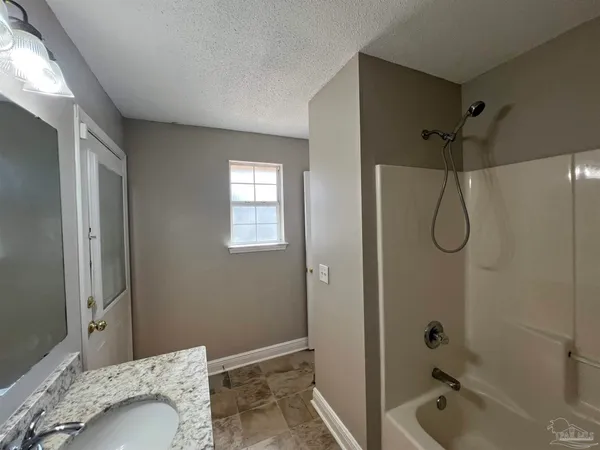 a bathroom with a tub shower vanity and a sink