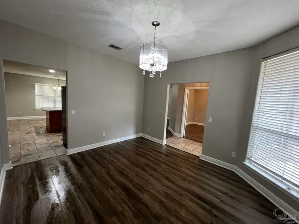 a view of a room with wooden floor staircase and a kitchen