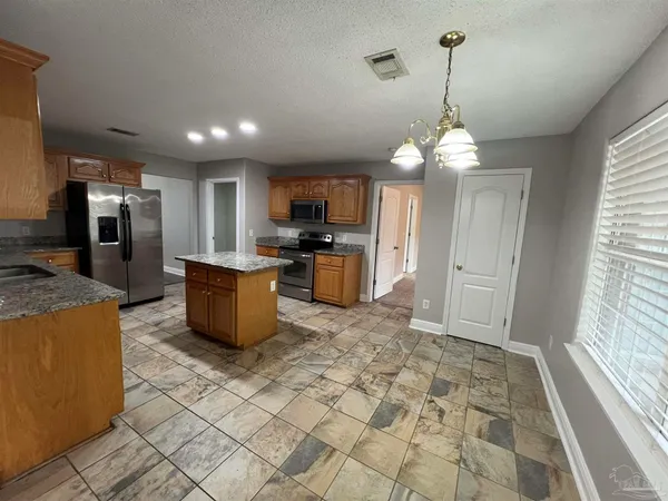 a kitchen with stainless steel appliances granite countertop a sink a stove and a refrigerator