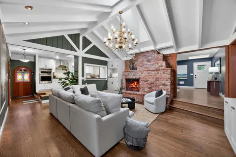 a living room with furniture a fireplace and a chandelier