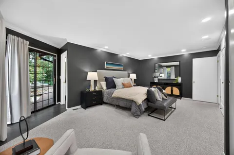 a bedroom with a bed couch and a large window