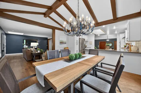 a view of a dining room with furniture a chandelier and wooden floor