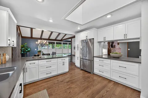 a kitchen with granite countertop white cabinets and stainless steel appliances