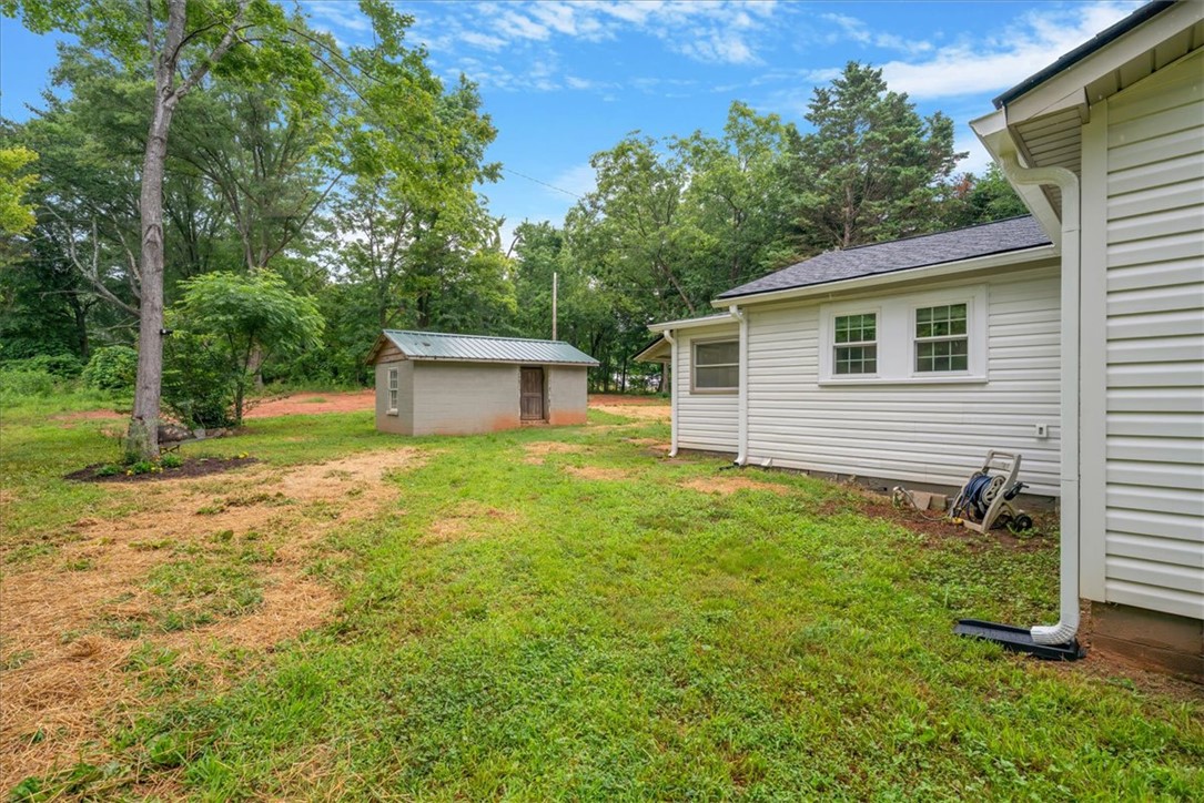 174 Holliday Road Six Mile, SC 29682 - Photo 38 of 49 A well-maintained side yard with grass and surrounded by mature trees for privacy