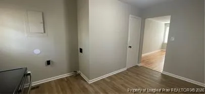 an empty room with wooden floor and entrance