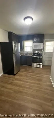 a view of kitchen with refrigerator and window