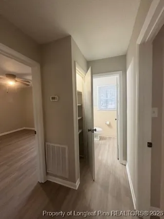 a view of a hallway with wooden floor and a living room
