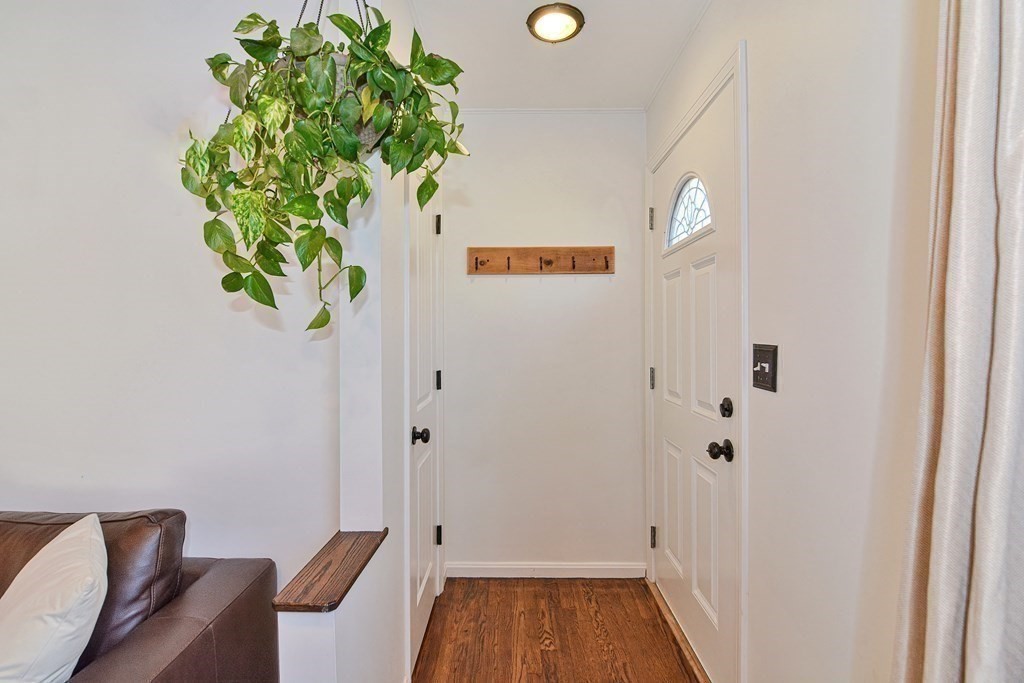 21 Coolidge Street Sherborn, MA 01770 - Photo 5 of 41 a view of a hallway with wooden floor and a potted plant