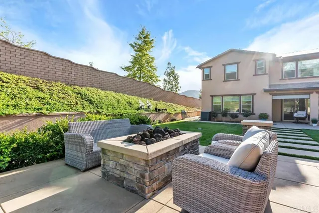 a view of a patio with couches table and chairs with potted plants and big yard