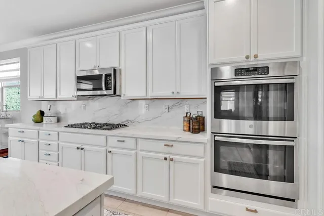a kitchen with cabinets stainless steel appliances and a sink
