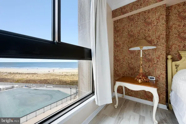 a bed sitting in a spacious bedroom next to a window