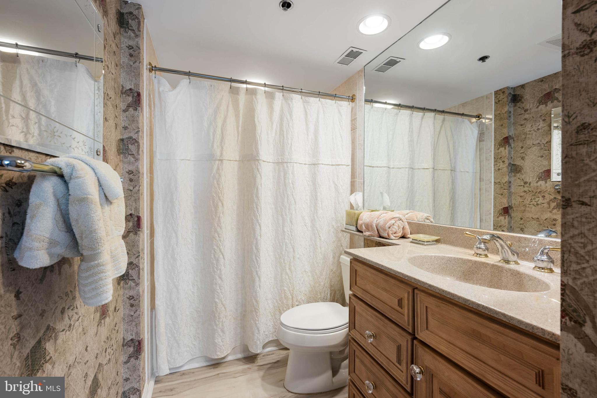 409 Georgetowne House Road Bethany Beach, DE 19930 - Photo 17 of 37 a bathroom with a granite countertop sink toilet and shower